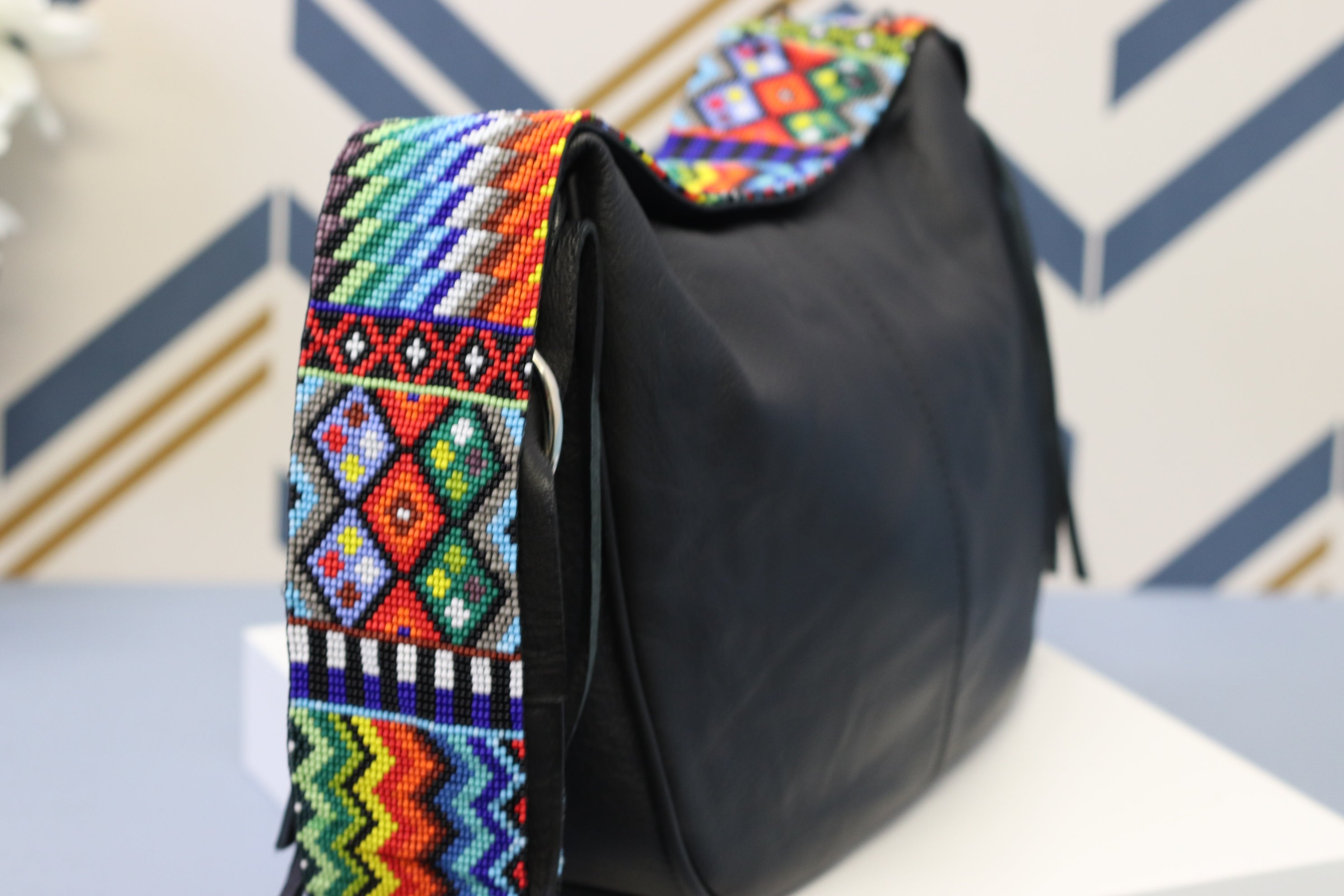Black Leather Messenger Bag with Hand Beaded Seed Bead Shoulder Strap. Handmade, Fast Shipping. Hand Beaded Shoulder Strap Multicolor. Cowhide Leather with Seed Bead Accent. Buy now at www.felipeandgrace.com