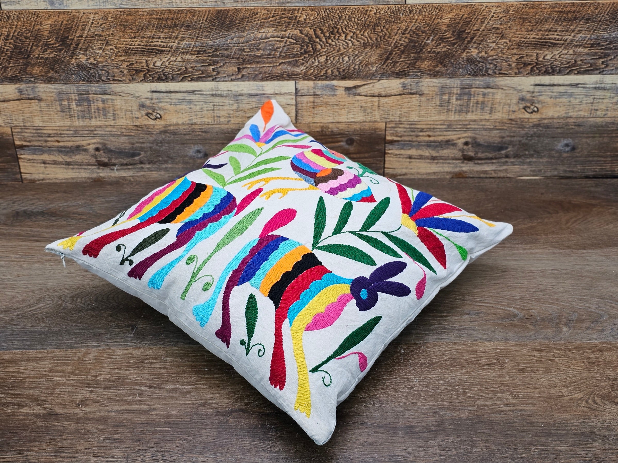 Square Otomi Tenango Pillow Cover with Hand Embroidered Birds, Flowers, and Animals in Vibrant Colors. Handmade in Mexico. Ships from the USA. Buy now at www.felipeandgrace.com.