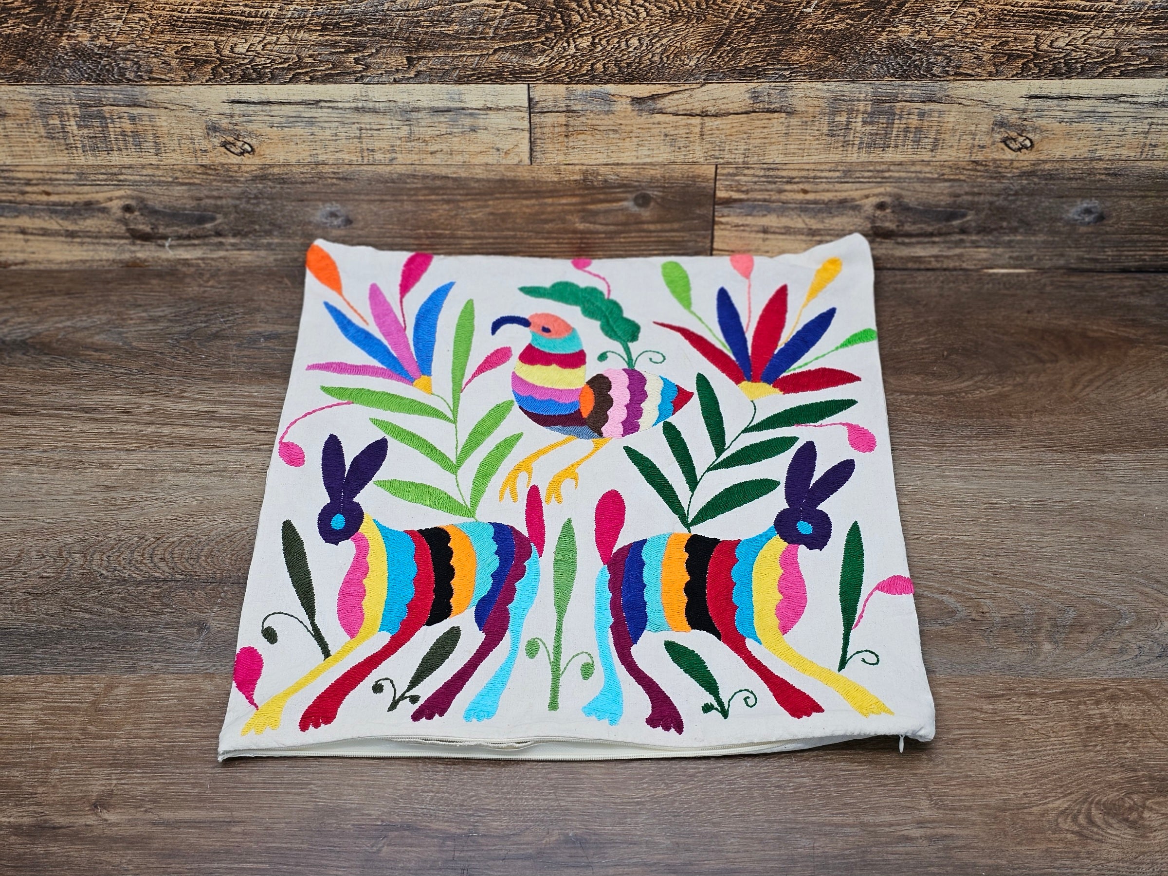 Square Otomi Tenango Pillow Cover with Hand Embroidered Birds, Flowers, and Animals in Vibrant Colors. Handmade in Mexico. Ships from the USA. Buy now at www.felipeandgrace.com.