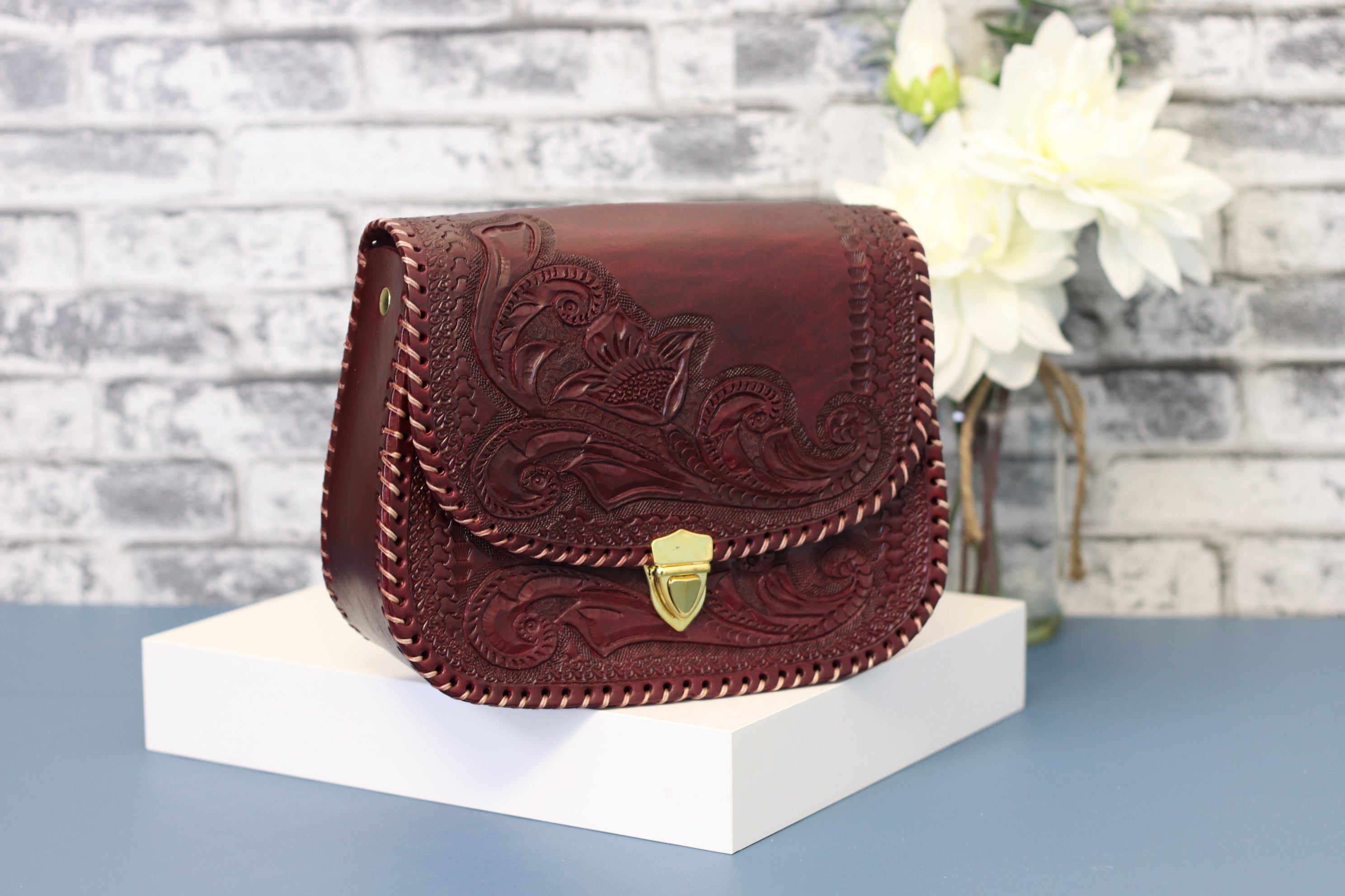 Wine color leather clutch,hand-tooled leather with gold clasp closure. Clutch Handbag. Made by artisans in Central Mexico, shipping from the USA. Handmade. Buy now at www.felipeandgrace.com. 