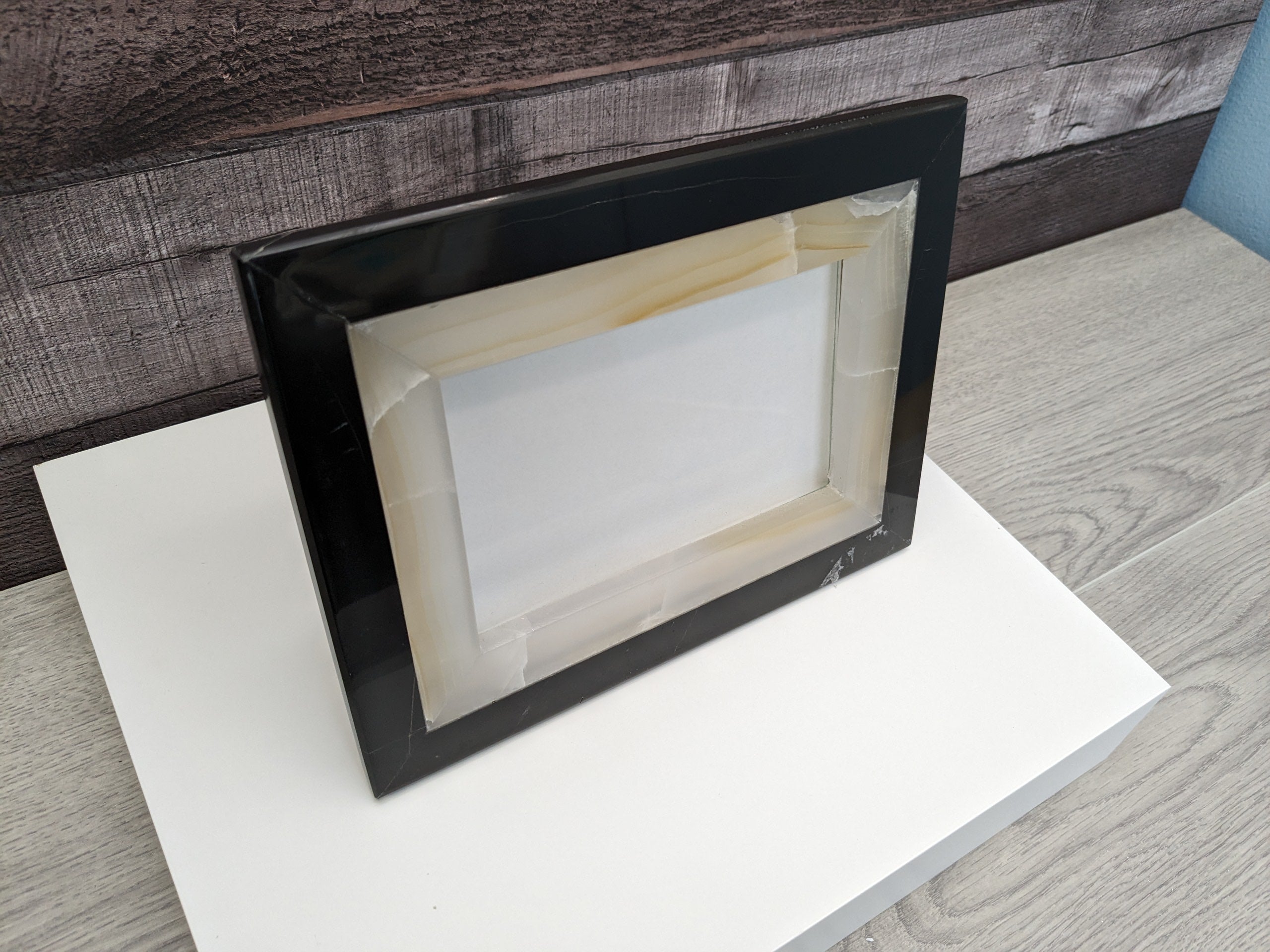 Black and White Onyx Frame with Glass Covering and a Travertine Stone Stand. Handmade in Mexico. We package and ship from the USA. Buy now at www.felipeandgrace.com.