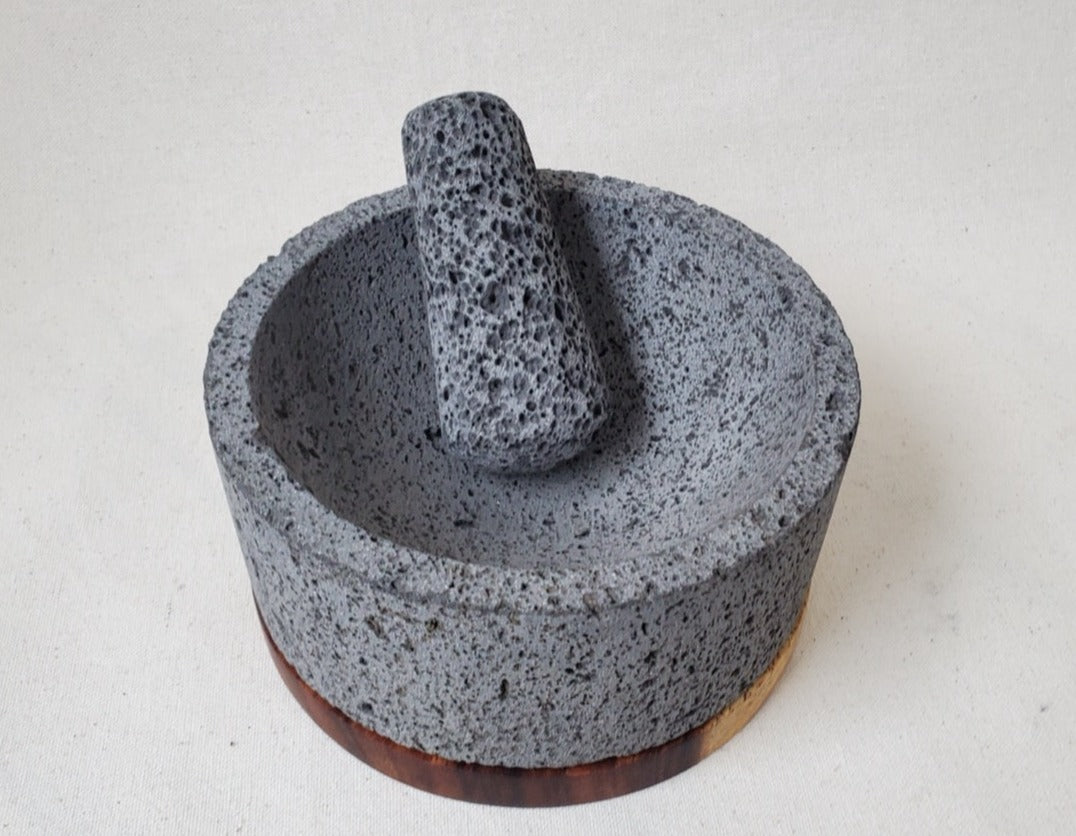 Authentic 8-inch Molcajete with a Wooden Base Pestle and Mortar Set. Made of pure basalt volcanic lava rock. Handmade in Mexico using traditional techniques. We hand finish, package, and ship from the USA. Buy now at www.felipeandgrace.com.